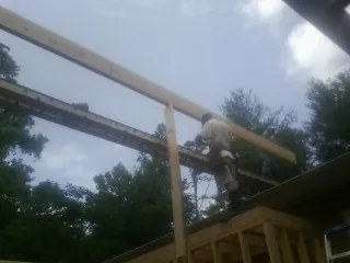 Carpenter setting a ridge beam over a new addition frame — Ice Dam Removal by Roofing Brothers in Channahon