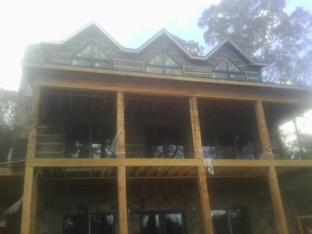 Dormers and porch framing on a large log home under construction — Roof Coating work by our crew in Channahon