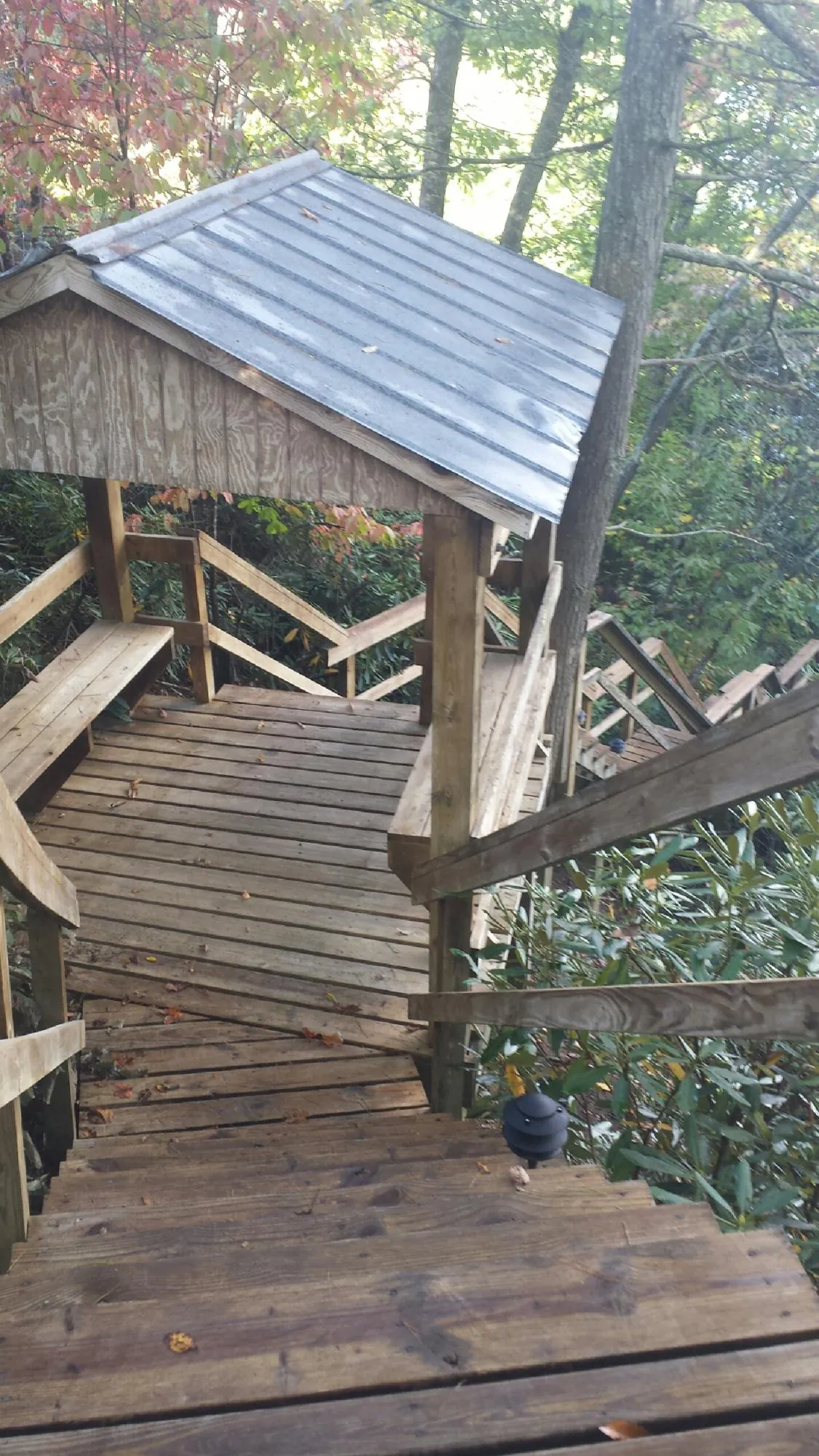 Metal roofed shelter over wooden steps on a wooded walkway — Skylight Repair & Installation work by our crew in Channahon