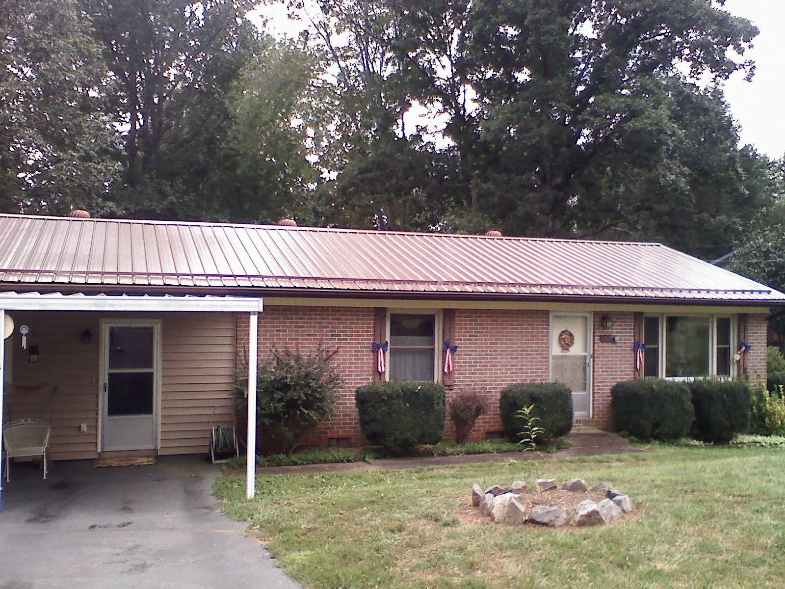 Bronze metal roof and carport on a brick ranch home — Roof Repair work by our crew in Channahon